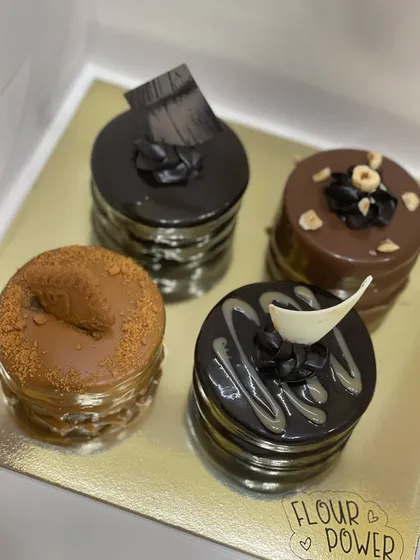An assortment of my mini mousse cakes, including Biscoff, chocolate truffle, and hazelnut flavors. These individual desserts are great for parties.