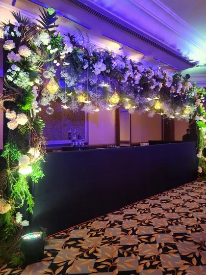 An angled view of the floral and light installation over the bar. This shows how we use decor to define different zones within a large event space, creating a dedicated and inviting area for drinks.