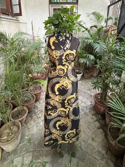 This black and gold print maxi dress, seen here on a mannequin, is all about the cut and fit. It’s a made-to-order piece that we tailor to your exact measurements for a flawless look.