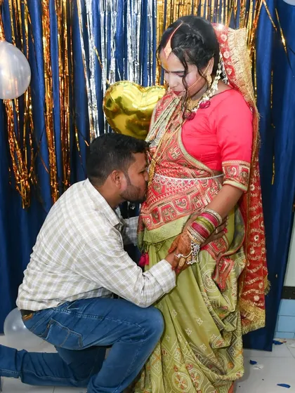 A touching moment where the father-to-be kisses the baby bump during a Godh Bharai ceremony. We capture these meaningful family traditions.