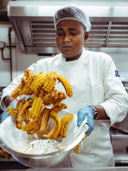 A chef tosses freshly fried corn ribs, another unique appetizer we've created for special events.