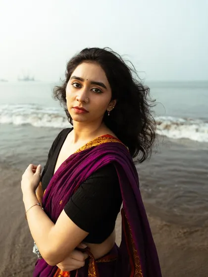 A close-up portrait that captures a soft, gentle expression, with the sea providing a simple and calming background.