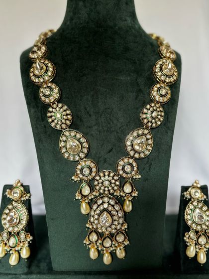 A long Polki necklace set with large, circular motifs and pearl drops. This rental set comes with matching oversized earrings.