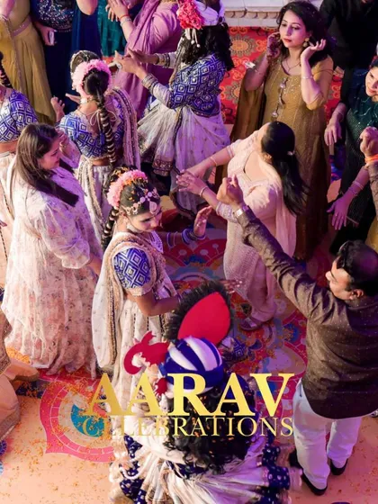 An overhead shot of the 'Phoolon ki Holi' celebration. The colorful floor, the dancing guests, and the traditional performers create a beautiful kaleidoscope of joy and movement.