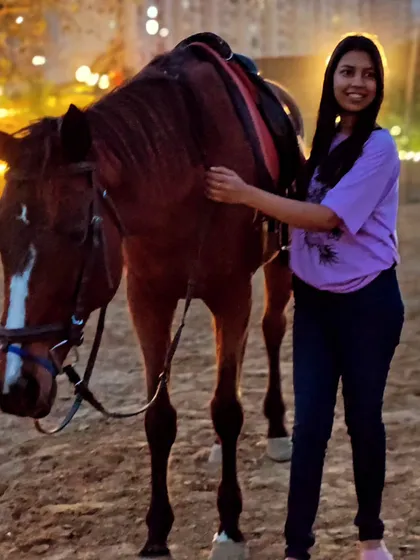 A beautifully lit evening portrait of a woman with one of our brown horses. The golden hour at our club provides soft, flattering light for stunning photos.