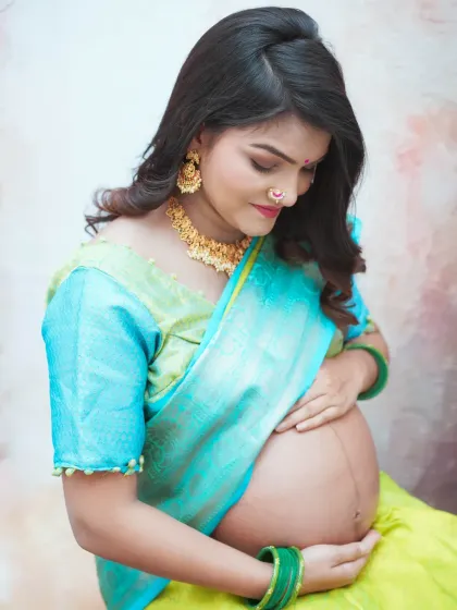Celebrating tradition with a beautiful maternity portrait in a vibrant turquoise and lime green saree. This style of shoot, often called 'godh bharai' photography, honors cultural heritage while capturing the pregnancy glow.