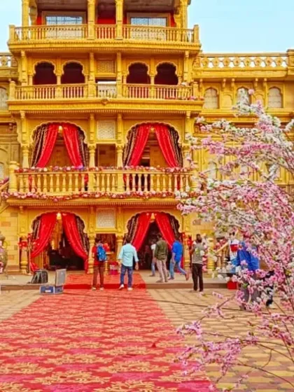 A palace-front wedding venue transformed with cherry blossom trees and a grand patterned red carpet, showing how I handle large-scale, opulent wedding decorations.