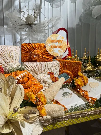 A closer look at the Rakhi trousseau, featuring gifts wrapped in beautiful orange and cream brocade fabrics.