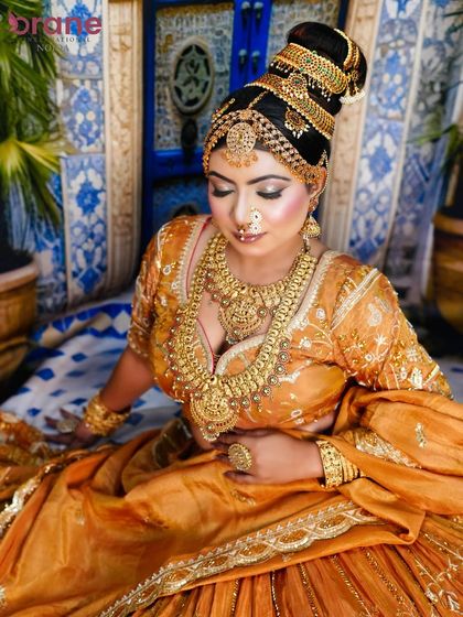 This seated pose captures the richness of the attire and the flawless execution of the makeup and hair.