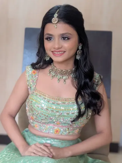 A smiling portrait from the Kirtan ceremony. The pastel green lehenga and subtle makeup create a look that is both traditional and refreshingly modern.