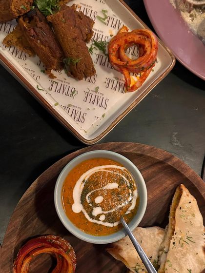 A top down view of the meal at Staple Delhi. This angle is great for showing the variety of dishes and the beautiful presentation on the wooden serving boards.
