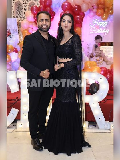 A power couple in coordinated black. Her custom black sequin fishtail lehenga is pure glamour, perfect for a grand birthday bash.