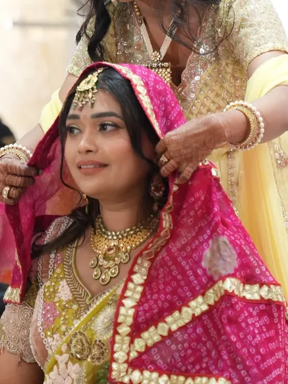 A tender moment as the bride is adorned with a traditional veil during her 'Paath Bithai' ceremony. These rituals are a beautiful part of the wedding journey.