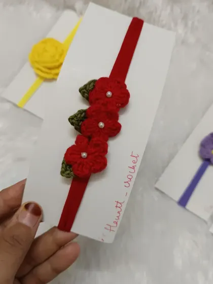 A close-up of the red flower nylon headband. The band is very soft and stretchy, making it comfortable for newborns and toddlers.