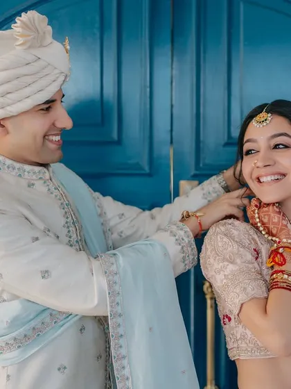 A quiet exchange of glances and soft smiles. Her makeup is fresh and natural, perfect for this intimate and candid moment with her groom.