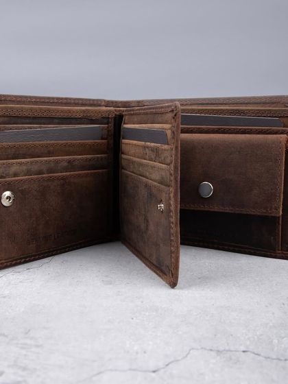 The interior of a distressed leather wallet, showcasing its coin pocket, card slots, and flip-up section for maximum functionality.