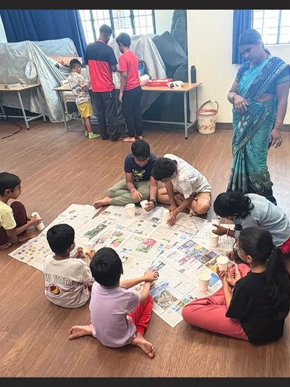 Our studio floor is covered with newspaper, ready for a fun and messy craft session. An instructor supervises as children focus on their projects, creating in a relaxed and pressure-free atmosphere.