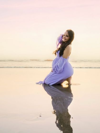 A joyful smile against a sunset sky. This portrait captures the pure happiness of the mother-to-be, with her reflection creating a beautiful symmetry on the wet sand.