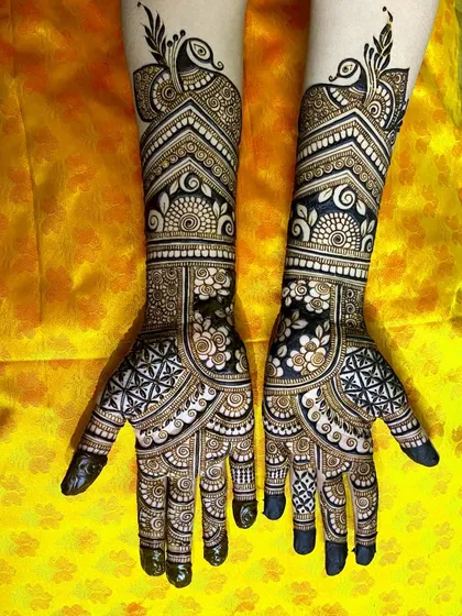 A bold and beautiful design for an engagement bride, featuring prominent peacock figures at the top of the forearm.