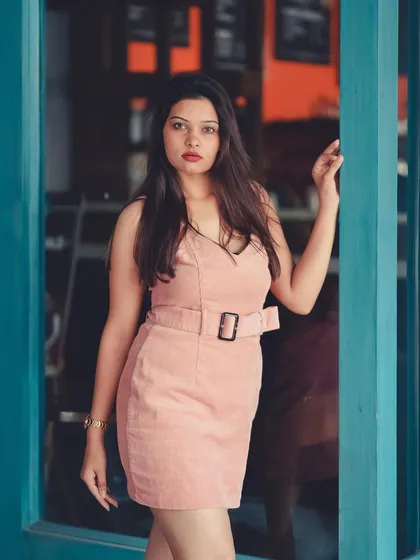 This corduroy pink dress is the star of the show. The contrasting blue door frame makes the color pop, which is a great technique for brand photography.