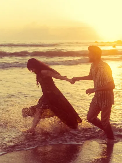 A romantic shot of a couple walking into the golden sunset on a beach in Goa. The warm tones and classic composition make this a timeless pre-wedding photograph.