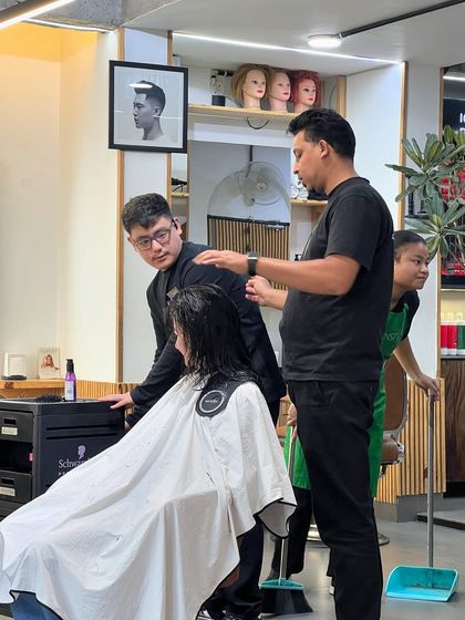 A teaching moment on the salon floor, where senior stylists guide and mentor our junior team members.