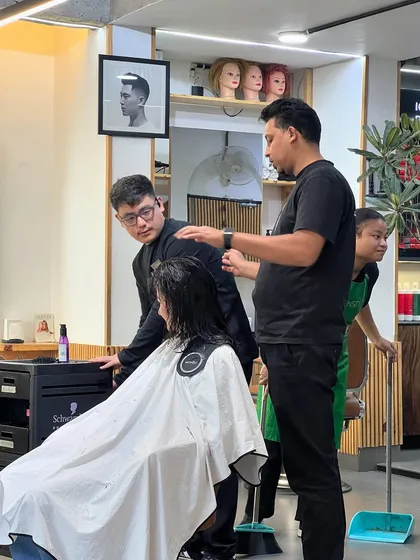 A teaching moment on the salon floor, where senior stylists guide and mentor our junior team members.