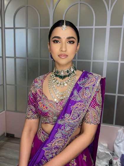 A direct, powerful portrait. This angle shows the perfect symmetry of the makeup and the beautiful way the layered necklaces are framed by the clean neckline and sleek hair.