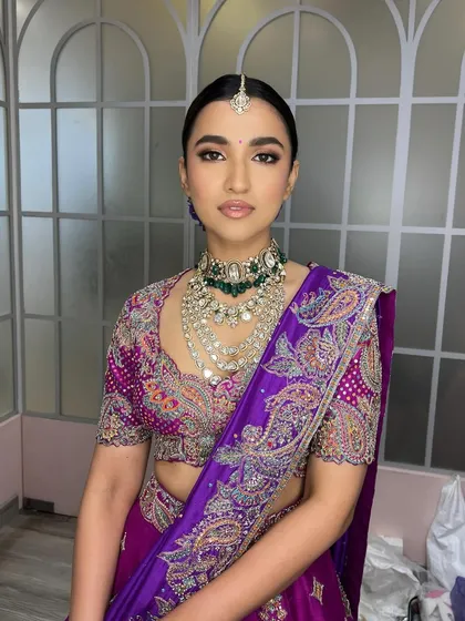 A direct, powerful portrait. This angle shows the perfect symmetry of the makeup and the beautiful way the layered necklaces are framed by the clean neckline and sleek hair.