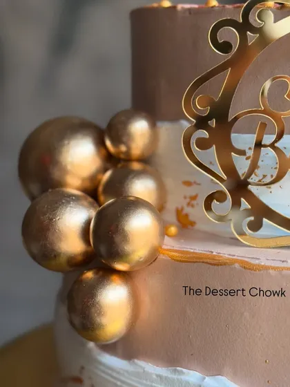 A close-up of the gold sphere details on the two-tier retirement cake. These add a touch of modern elegance to the design.