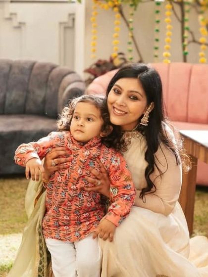 A candid portrait of a mother and her child in a relaxed, outdoor setting.