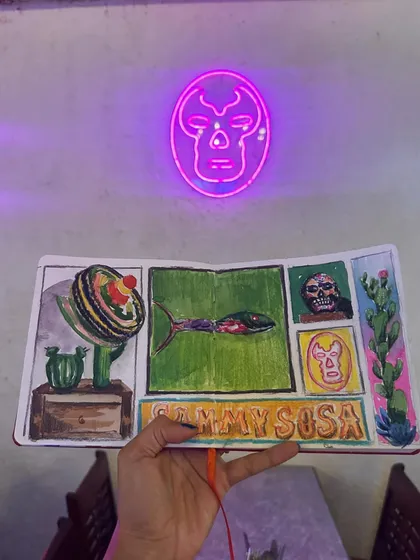 The cool neon glow of a skull sign at Sammy Sosa provides a dramatic backdrop for my sketchbook page.