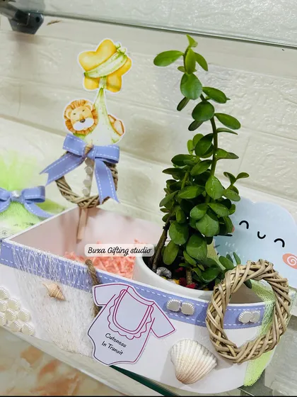 A detailed shot of the boat-shaped hamper, highlighting the custom cutouts, lilac ribbon, and seashell embellishments.