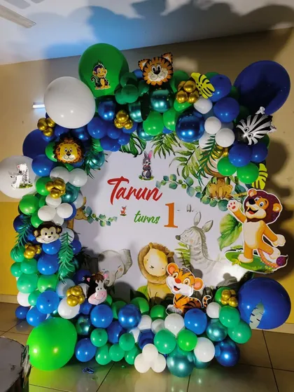 A close-up of the balloon frame and backdrop for Tarun's party, showing the vibrant colors and animal details.