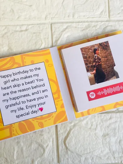 An inside look at the Spotify slider card, showing the personal birthday message and the first photo with its scannable song code.