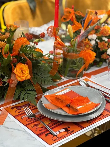 For this elegant Hermès-inspired baby shower, every detail on the table was thoughtfully curated. The custom placemats, vibrant orange floral arrangements, and personalized menus created a truly luxurious and intimate setting.