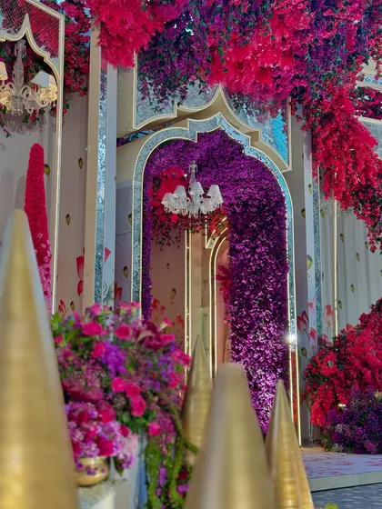 A detail of the entrance, where an archway of purple flowers creates a dramatic and inviting portal into the celebration.