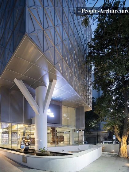 The corner view of MAP at dusk, where the illuminated interior and the structural 'tree' column become prominent features.