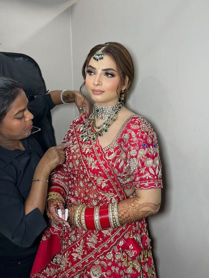 A behind-the-scenes shot of the final touches. Every detail, from the makeup to the dupatta setting, is meticulously handled by my team.