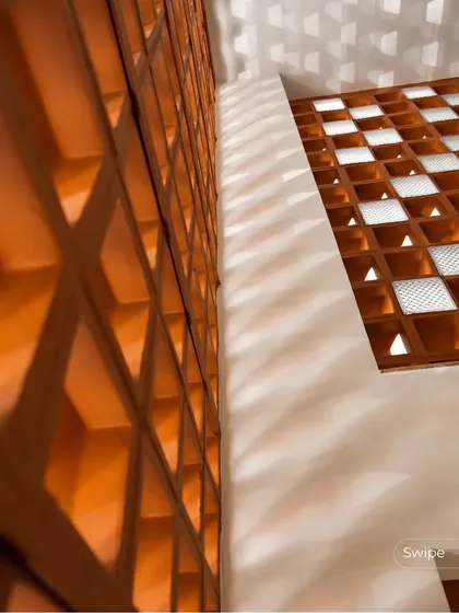 The dramatic play of light and shadow created by a terracotta jali screen in the Anand Residence, turning a simple wall into a dynamic piece of art.