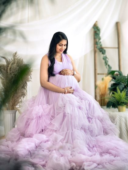 A soft and gentle portrait, with the expecting mother looking down at her bump with love.