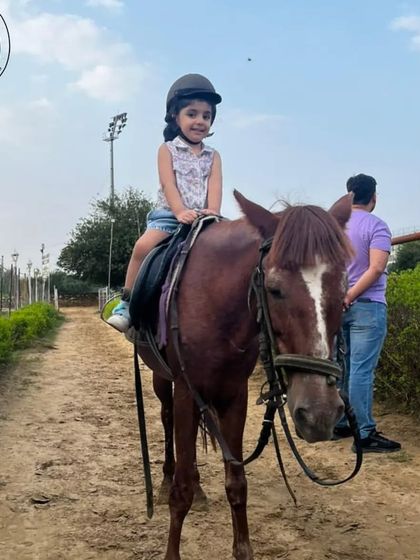 A young girl enjoys her ride down one of our pathways, getting comfortable in the saddle with a big smile.