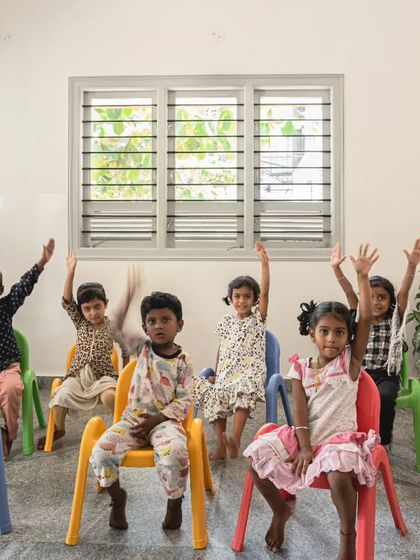 A school should be a place of opportunity and eagerness. Here, the children are engaged in their study zone, a space designed to be functional, playful, and safe. The simple, movable chairs allow the room to be reconfigured for different activities, from lessons to games.