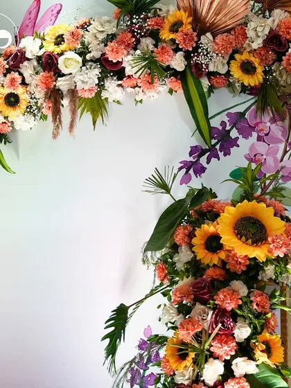 A magnificent floral arch designed for a 'Phoolon ki Haldi' ceremony. Bursting with sunflowers, marigolds, and orchids, this backdrop created a joyful and auspicious setting for the pre-wedding celebration.