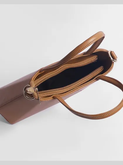 A top-down view into the open handbag, showing its multiple compartments and storage capacity.