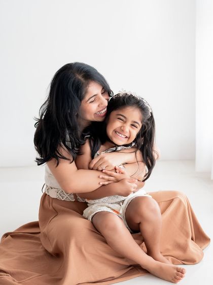 A mother and daughter sharing a big, joyful hug.