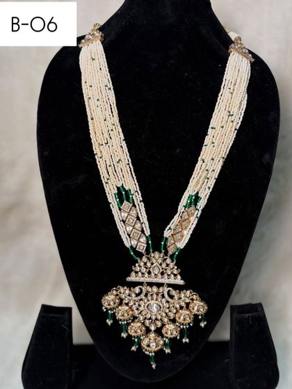 This is the long necklace from set B-06, which can be rented separately. It features strands of pearls and a heavy, antique-style pendant for a classic look.