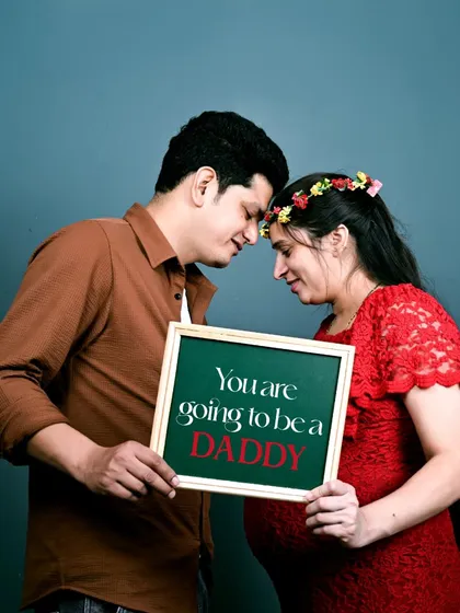 A fun and emotional moment during a studio maternity session. Using props like this slate adds a personal and playful touch to announce the great news. Let's tell your story together.