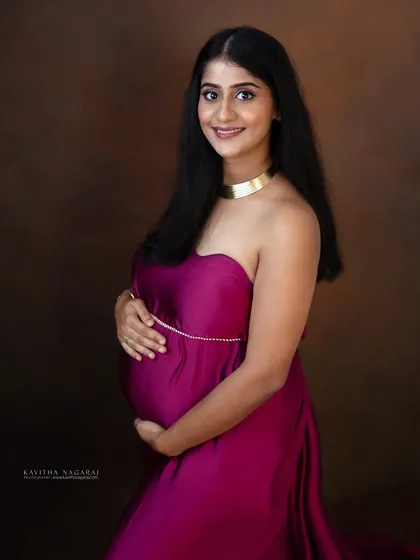 A beautiful portrait of a mother-to-be, looking confident and happy in a flowing magenta gown. A perfect way to remember the strength and beauty of pregnancy.