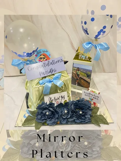 Reflecting love in every detail. Our mirror base platters add a touch of glamour to any celebration, like this congratulatory gift complete with balloons and floral decorations.